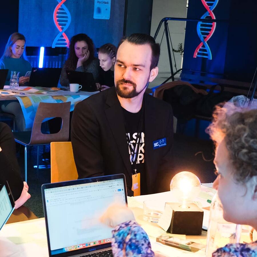 Participants collaborating in teams at PsyHack 2023, a psychology hackathon focused on real-world challenges.